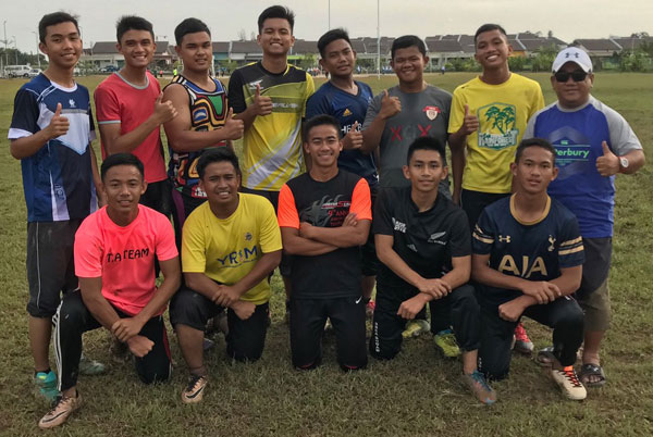 Coach Zulkaranainhisham (right) with his lads at the school rugby ground at Matang before a training session.