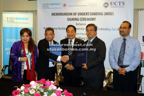 Lim (second left) and Hakim shaking hands after the MoU signing, witnessed by Wong (centre). Also seen are Cheah (left) and Zainal. — Photo by Jeffery Mostapa